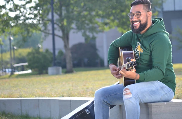 guy sitting playing guitar